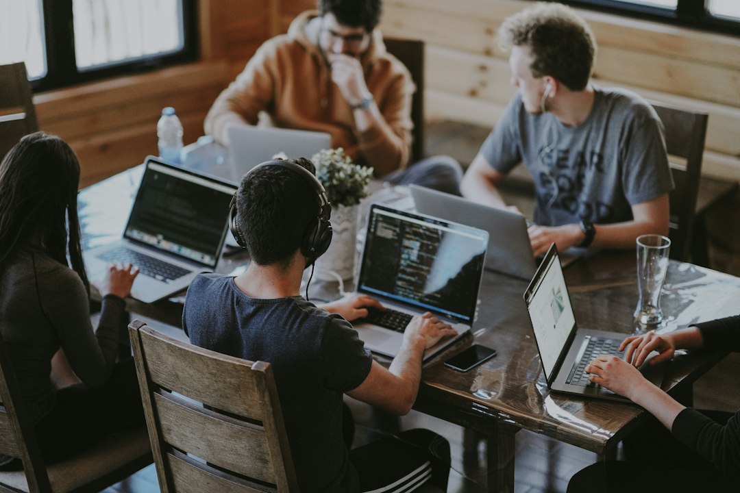 People collaborating around laptops in a real office; illustrative stock photograph